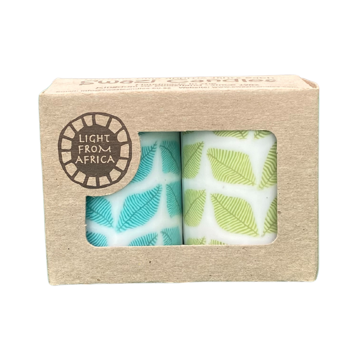 Two white candles, one with blue and one with green fern leaf patterns on them. They are in a craft box with Light from Africa printed and Swazi Candles on the top of the box.