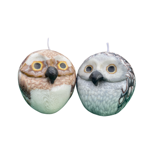 A brown and a grey round owl candles on a white background.