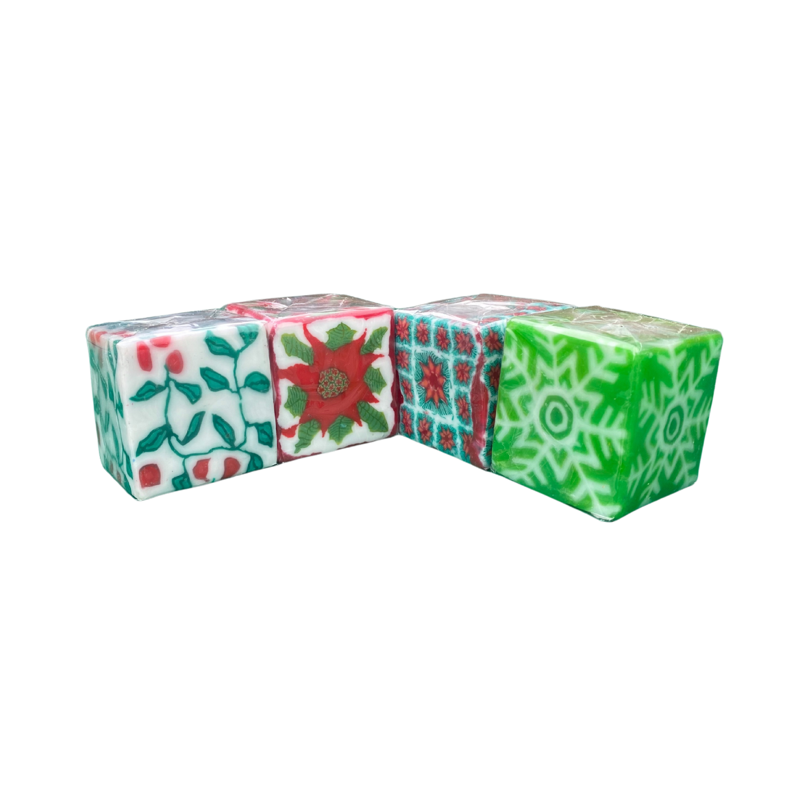 A pack of 4 Swazi candles with Christmas designs including holly, poinsettia and snowflakes.