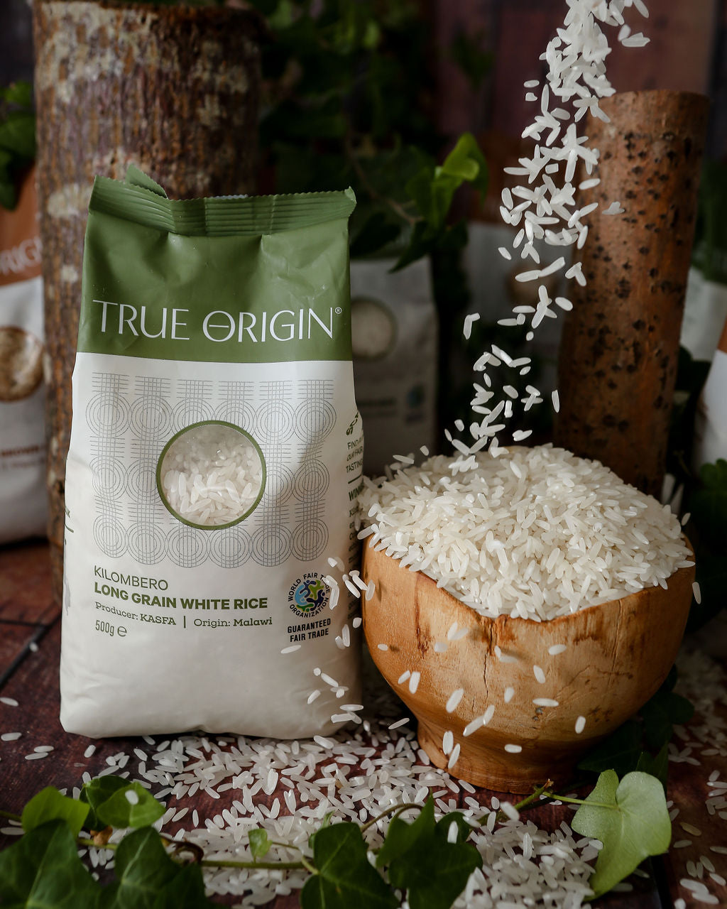 A bag of white Kilombero long grain aromatic rice from Malawi with some rice grains being poured into a bowl from above.