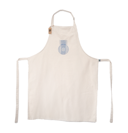 A beige apron with a blue geometric pattern and the 'True Origin' brand logo on the front. It has canvas ties for the neck and waist.