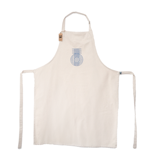 A beige apron with a blue geometric pattern and the 'True Origin' brand logo on the front. It has canvas ties for the neck and waist.