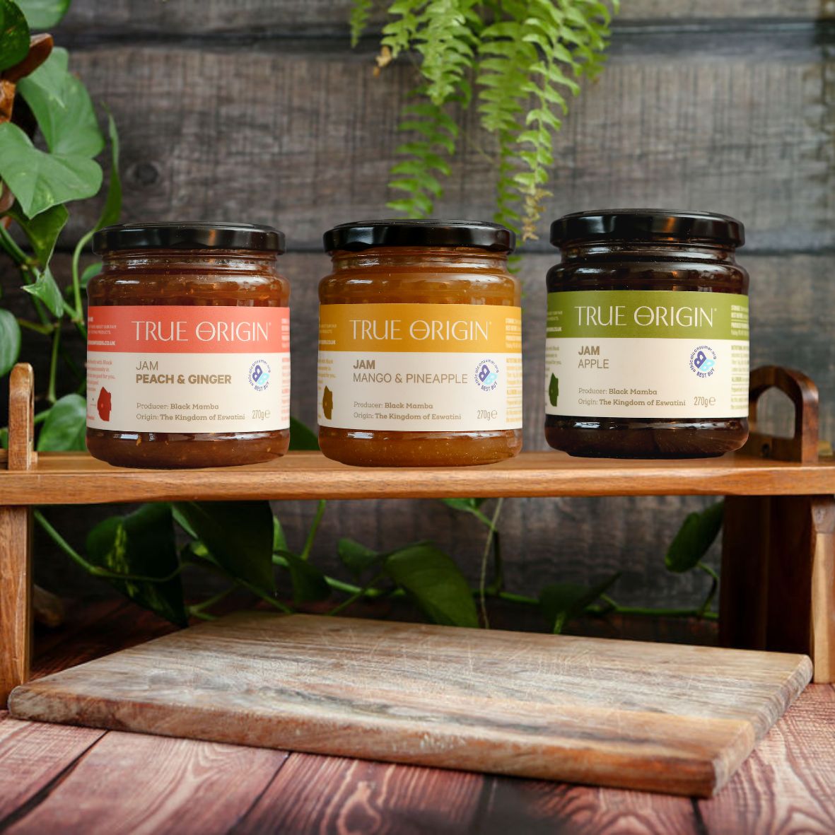 Three jars of True Origin jam on a wooden shelf with a rustic background