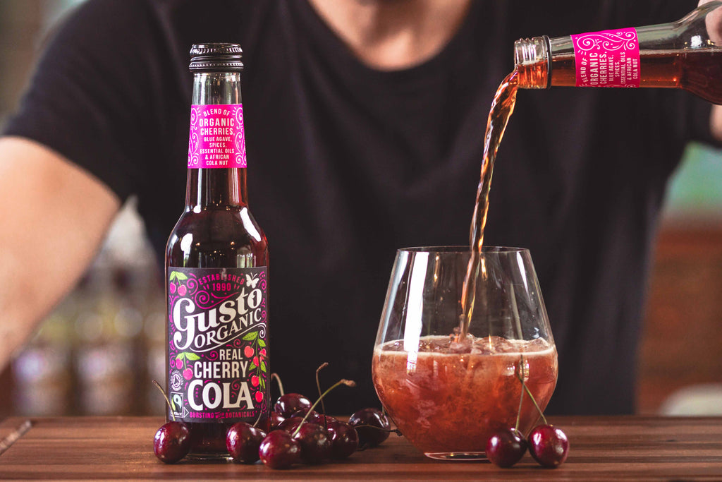Gusto Organic Real Cherry Cola being poured into a glass with ice
