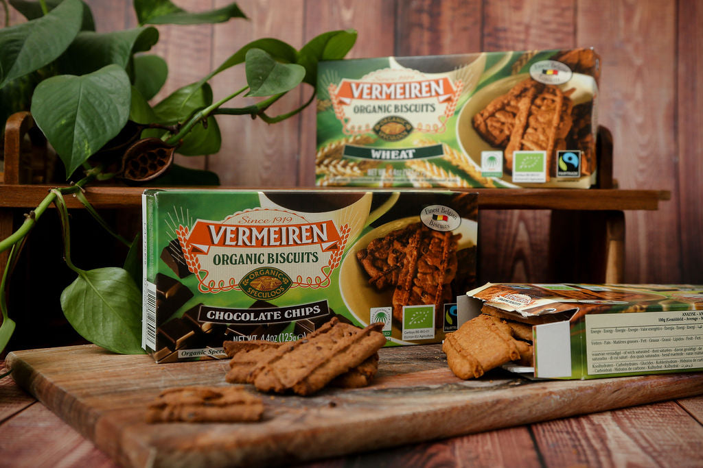 A packet of Fairtrade Vermeiren organic wheat and choc chip biscuits from Belgium next to an open packet with some loose biscuits falling out. 