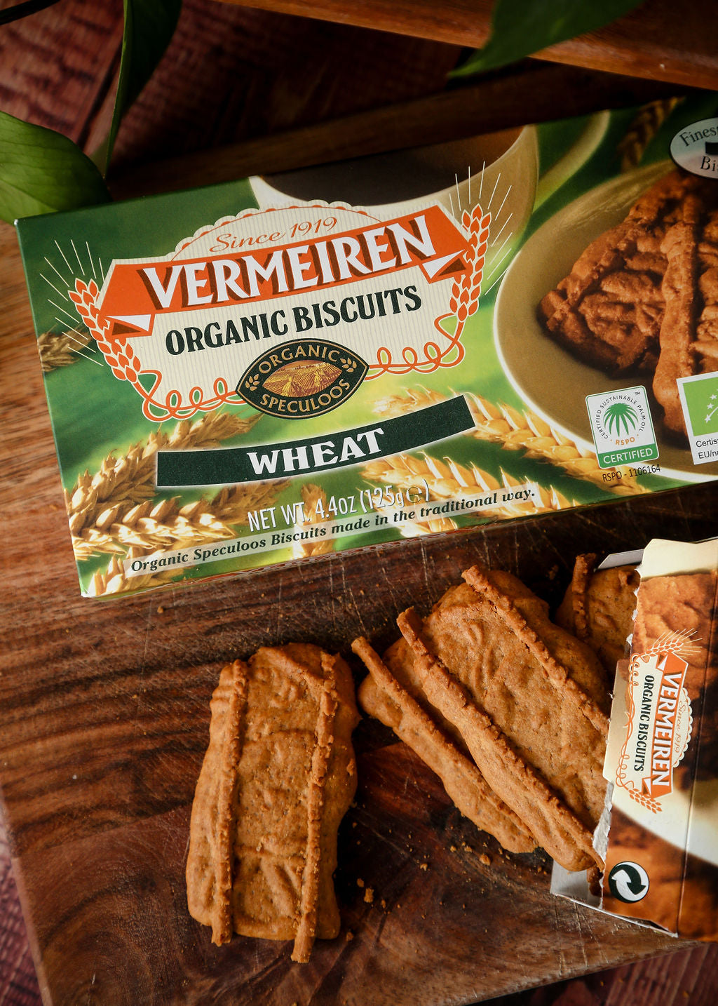 A packet of Vermeiren organic wheat biscuits beside some loose speculoos biscuits.