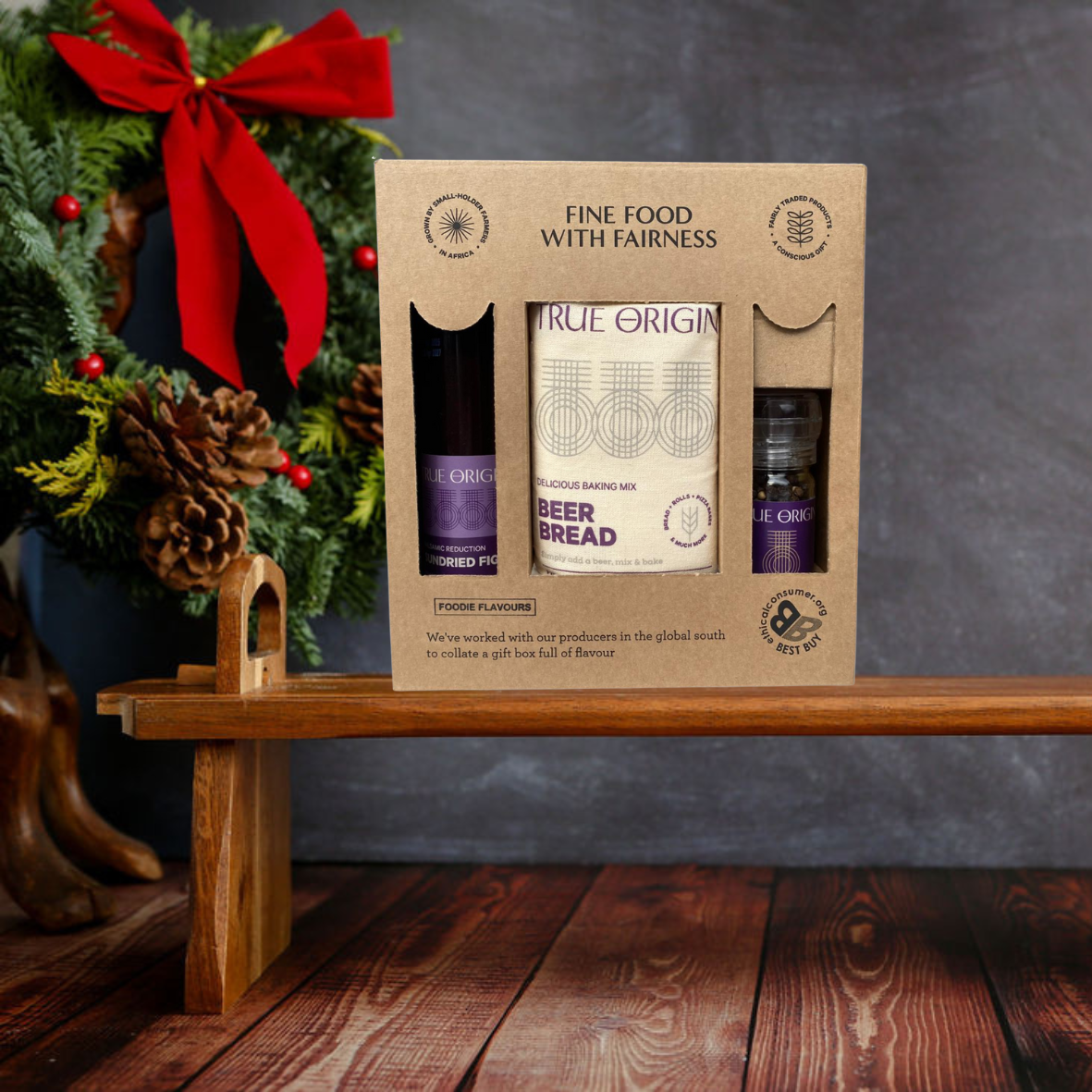 Gift set with 'True Origin' products on a wooden shelf with a festive background