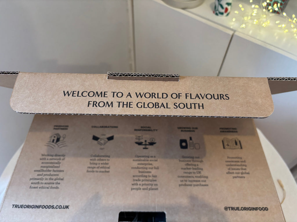 Cardboard hamper box with text 'Welcome to a world of flavours from the global south' and branding details.