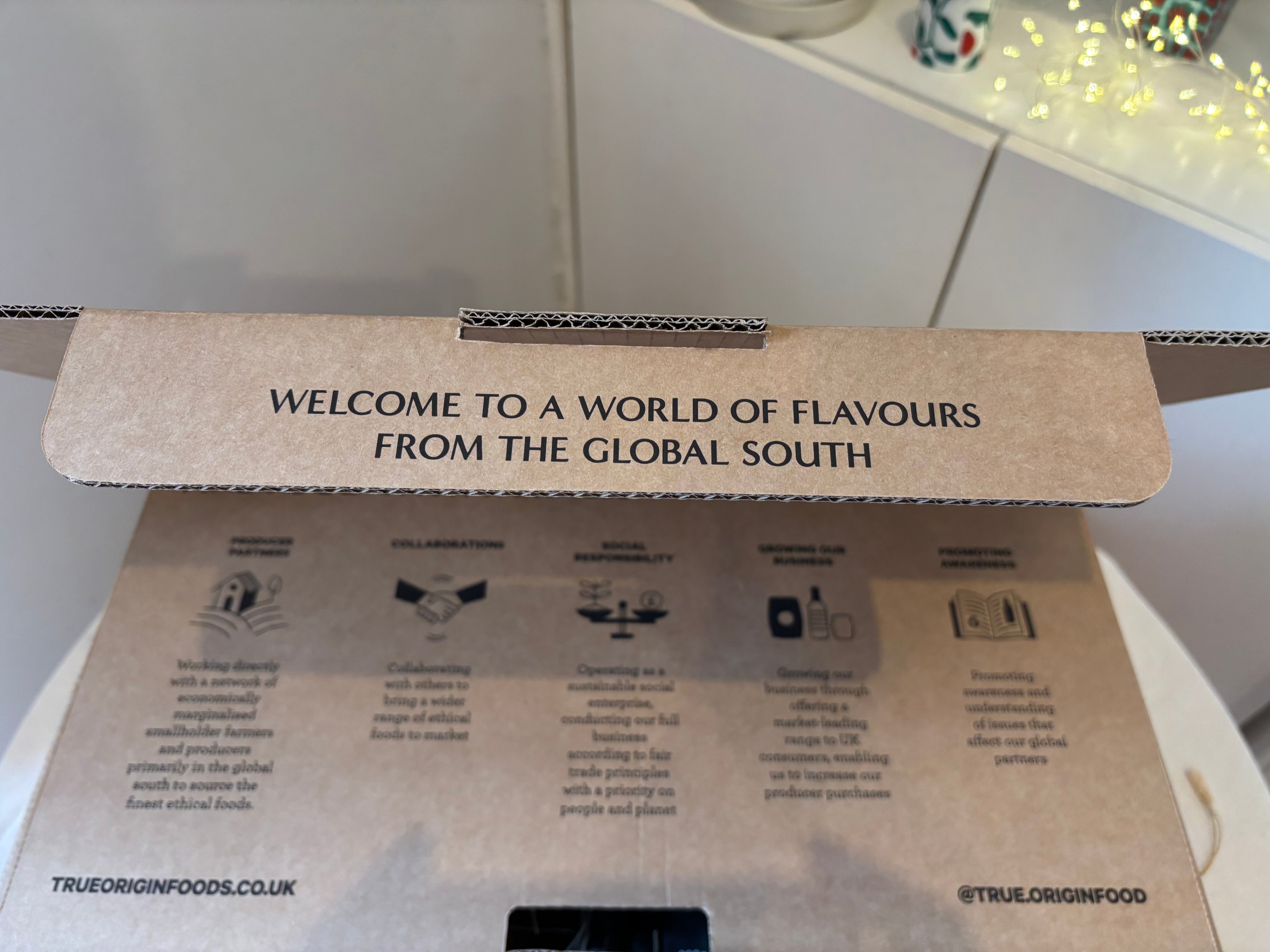 Cardboard hamper box with text 'Welcome to a world of flavours from the global south' and branding details.