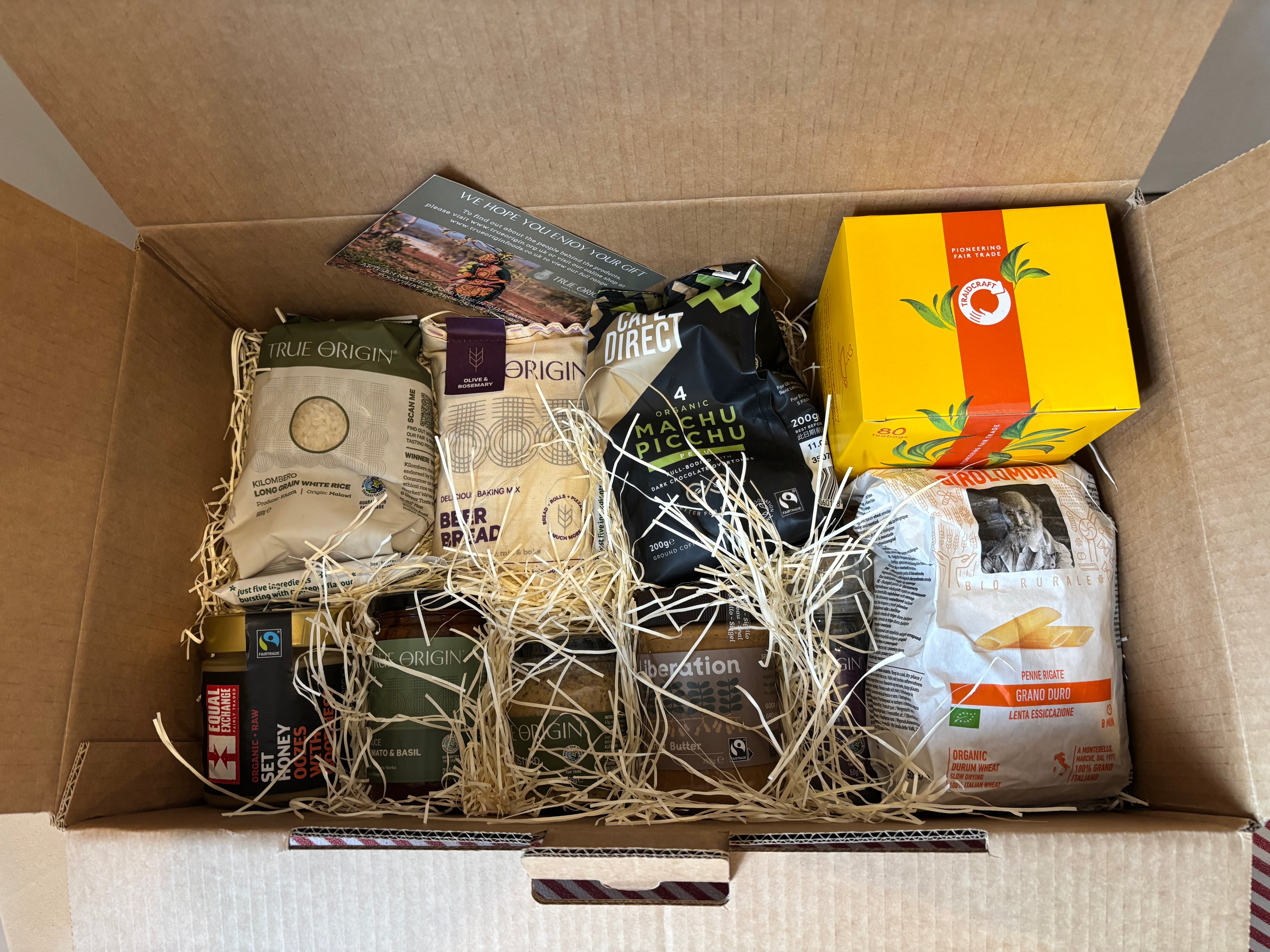 Open Family Selection Hamper box containing various packaged goods including tea and snacks.