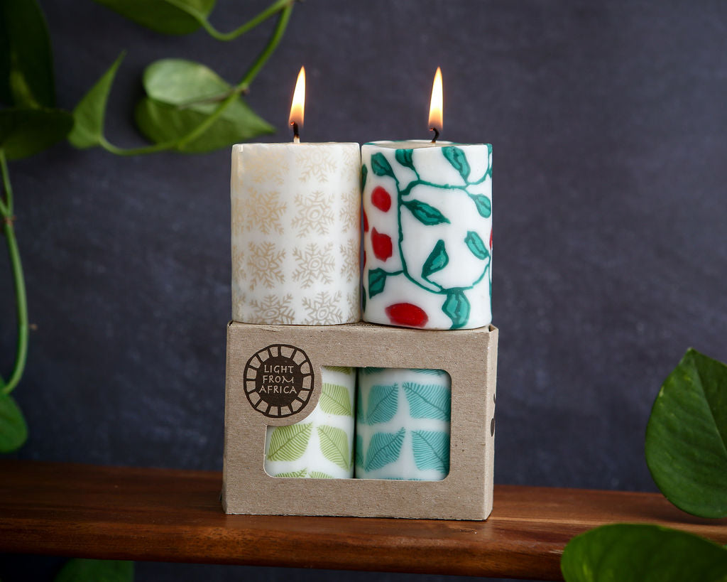 Two lit candles in a decorative box with a dark background