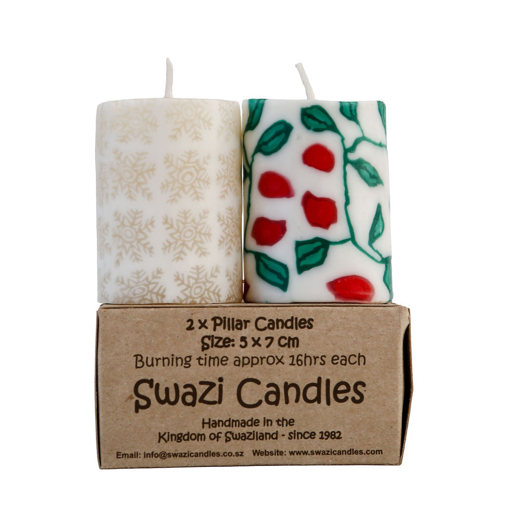 Two pillar candles in a cardboard box with Swazi Candles branding.