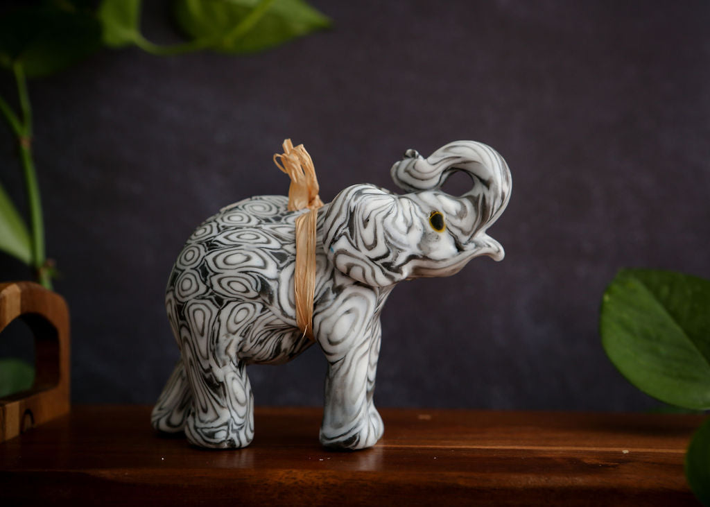 Decorative elephant candle with intricate patterns on a dark background
