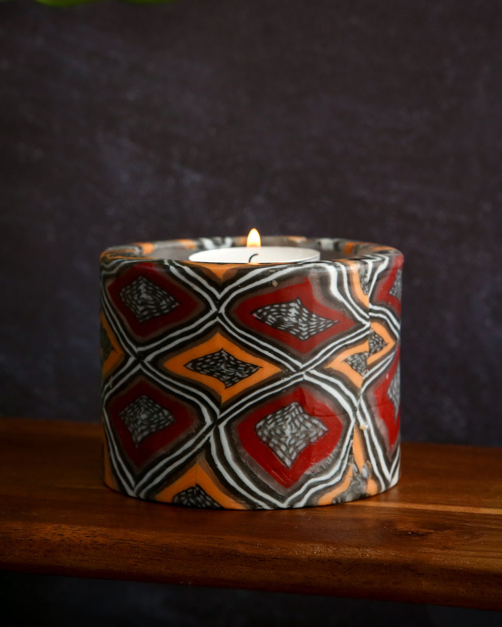 Decorative candle holder with geometric pattern on a wooden surface