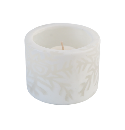 White snowflake tealight candle holder containing an unlit candle on a transparent background