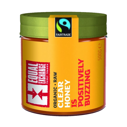 A jar of organic raw clear honey with a green lid, labeled with the brand Equal Exchange and the Fair Trade logo, indicating a 500g weight.