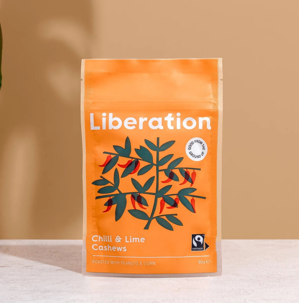 Packaging of Liberation Foods Chilli & Lime Cashews with an illustration of cashew nuts and chilli peppers on an orange background.