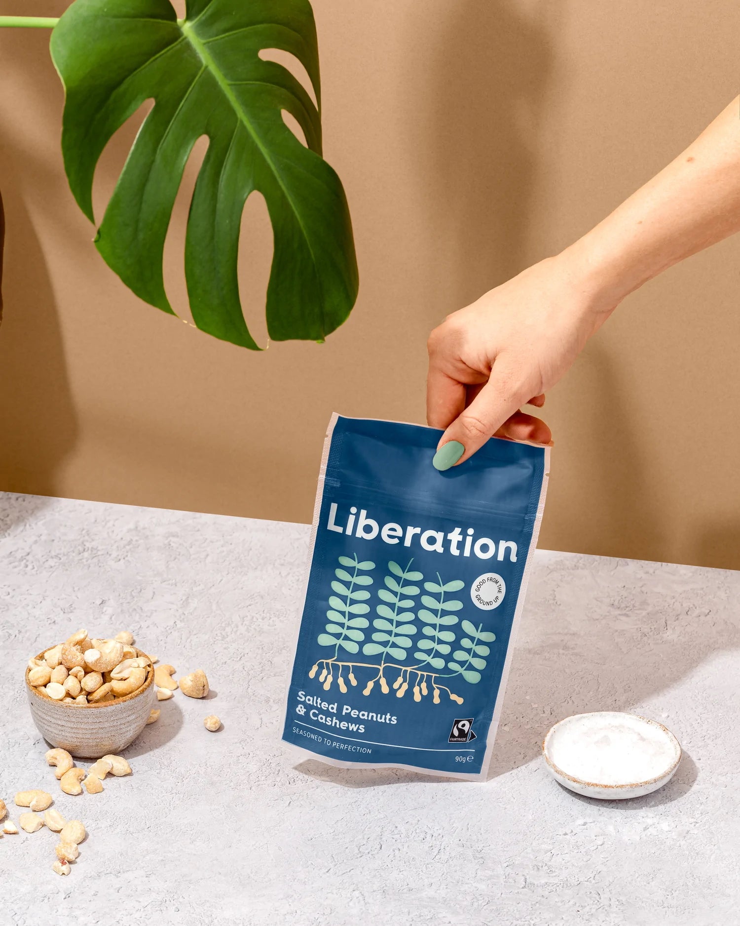 A blue bag of fair trade Liberation Foods salted peanuts and cashew nuts.