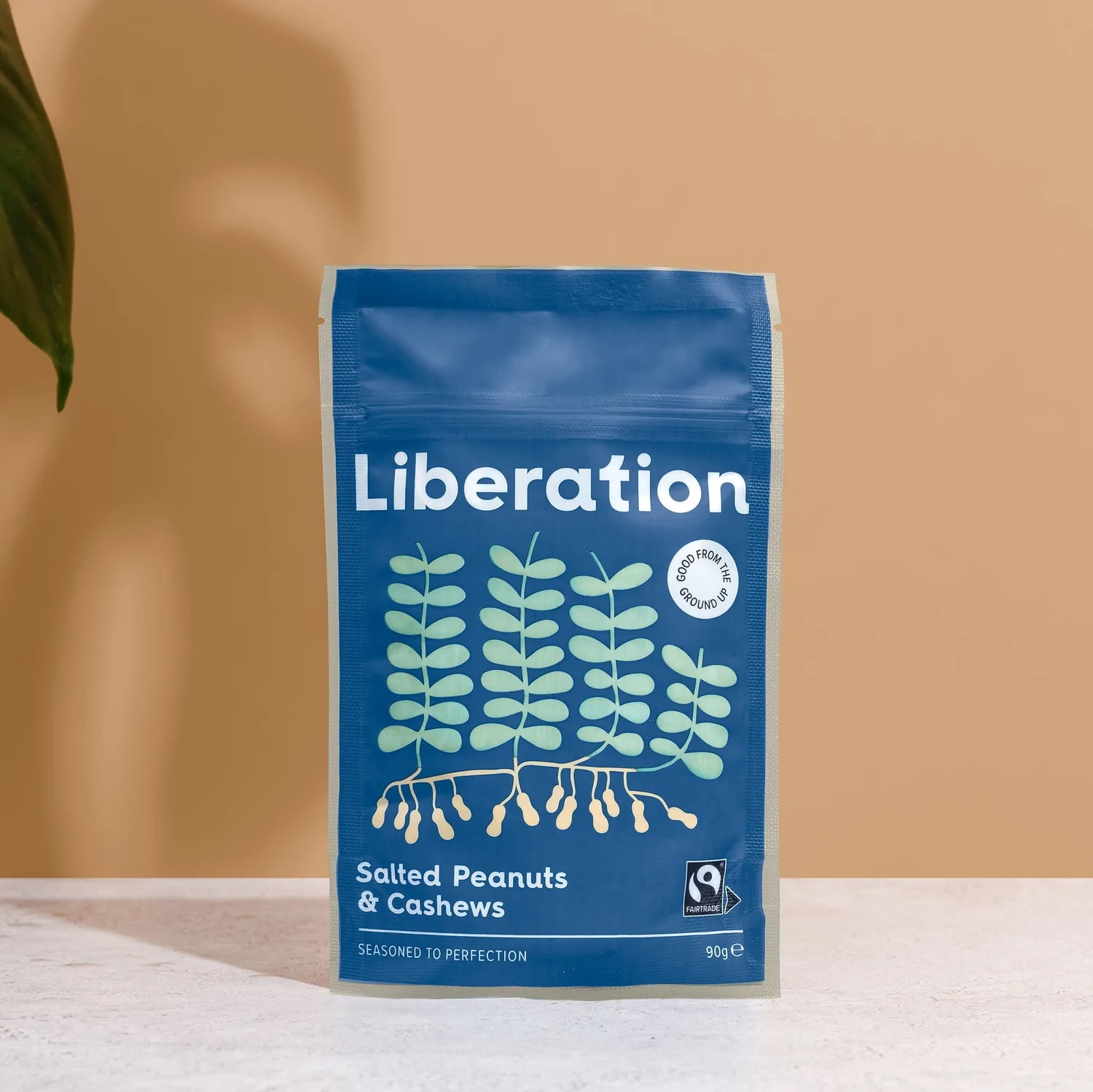 A blue bag of fair trade Liberation Foods salted peanuts and cashew nuts.